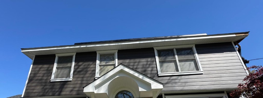 Revestimiento de cemento de fibra carbón, moldura blanca y pórtico en una remodelación exterior de Ridgewood NJ