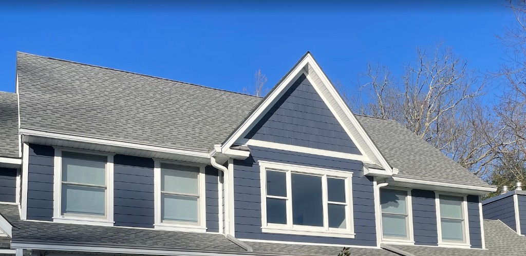 Navy siding, white trim, and new roof on a coordinated North Jersey exterior remodel