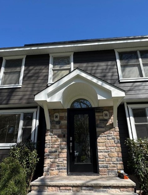 Cultured stone columns and white gabled portico with black glass entry door, Bergen County NJ