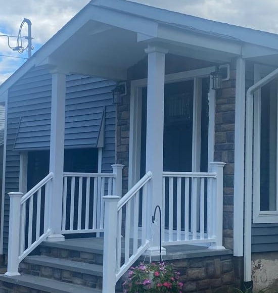 Pórtico con hastial, piedra cultivada y puerta de entrada negra, condado de Bergen NJ