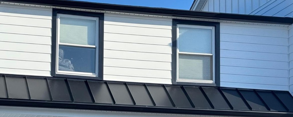Revestimiento blanco, moldura negra y ventanas coordinadas en una remodelación exterior completa de Wayne NJ