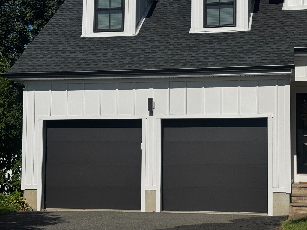 Board and batten garage opening with white trim surrounds, North Jersey